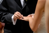 Photograph of a man placing a ring on a woman's finger