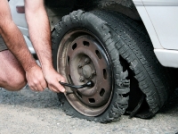 Photograph of a car wheel with a shredded tire